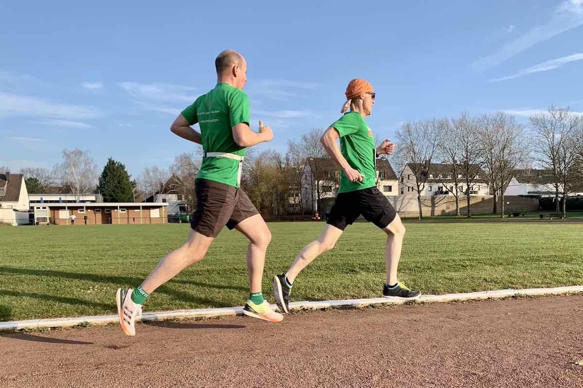 Zwei Läufer – wahrscheinlich auch Virtual Runners – beim Lauftraining auf einen Aschenbahn.